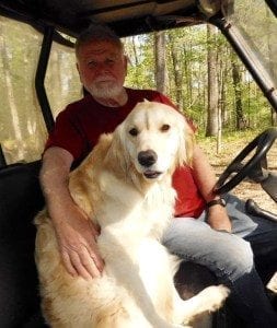 man with arm around dog in vehicle