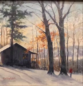 cabin in snow with man walking next to trees