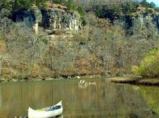 canoe along river with bluff in background